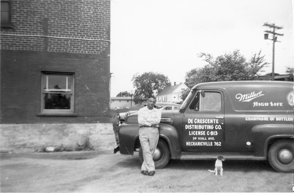 Men leading against a car