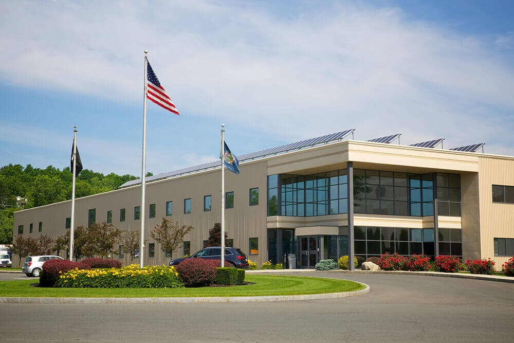 Building with solar panels on the roof and flags out front